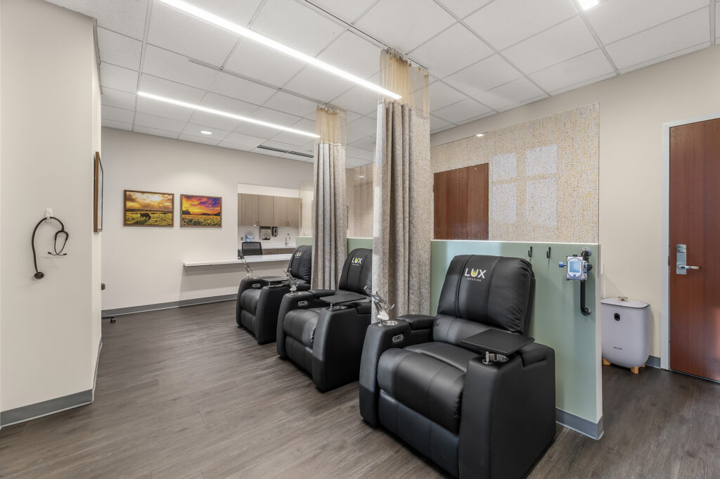 Shared infusion room with three comfy black chairs